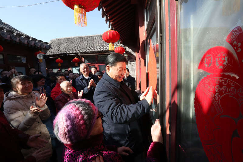 2019年2月1日上午，習近平在北京前門(mén)東區草廠(chǎng)四條胡同32號院，高興地拿起一幅“?！弊?，親自貼到門(mén)上，給這里的老街坊們拜年。新華社記者 鞠鵬 攝