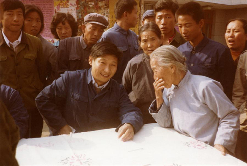 1983年，時(shí)任河北正定縣委書(shū)記的習近平（前排居中），臨時(shí)在大街上擺桌子聽(tīng)取老百姓意見(jiàn)。